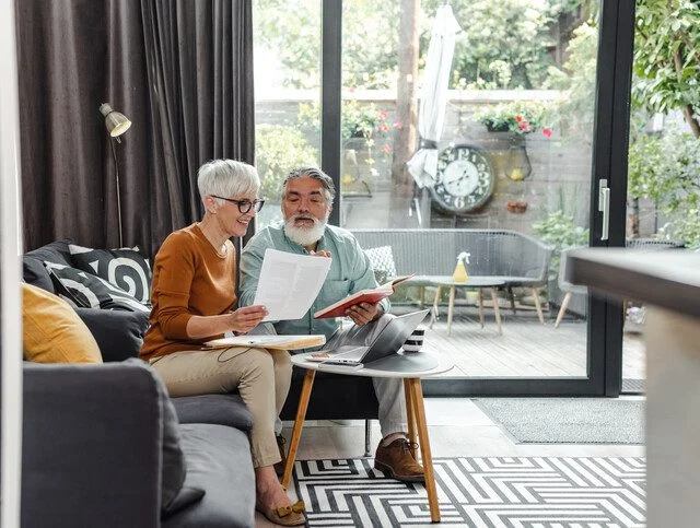 Senior couple discussing home finances and using laptop