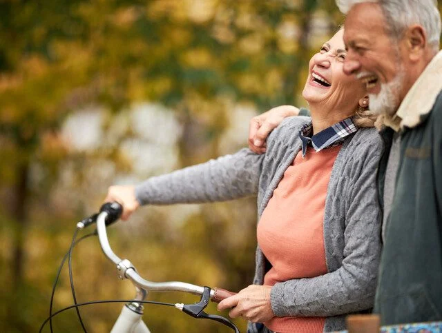 Cheerful senior couple taking an autumn walk at the park.