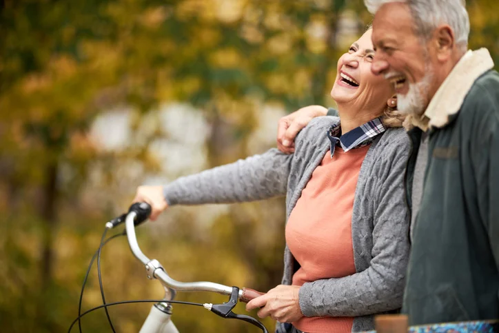 Cheerful senior couple taking an autumn walk at the park.