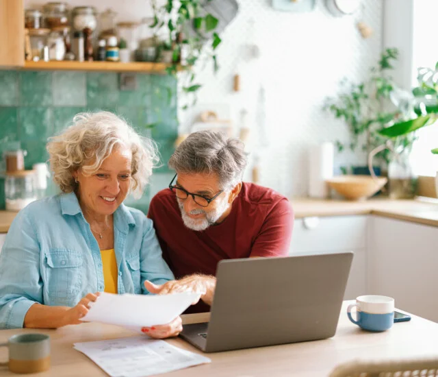 Senior couple managing home finances on laptop