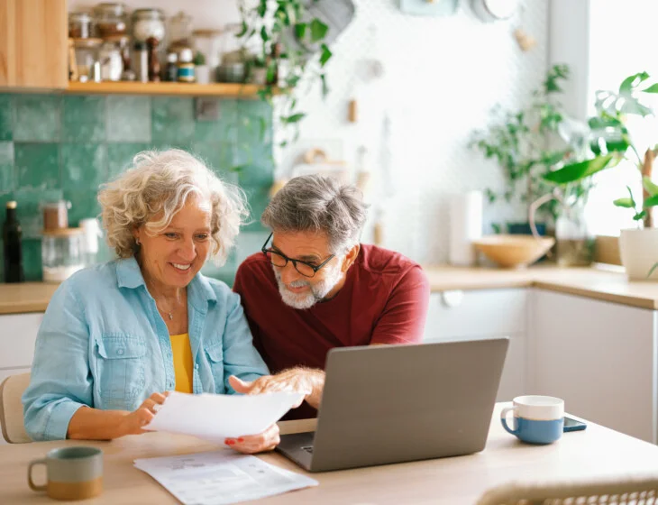 Senior couple managing home finances on laptop