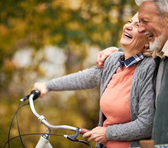 Cheerful senior couple taking an autumn walk at the park.